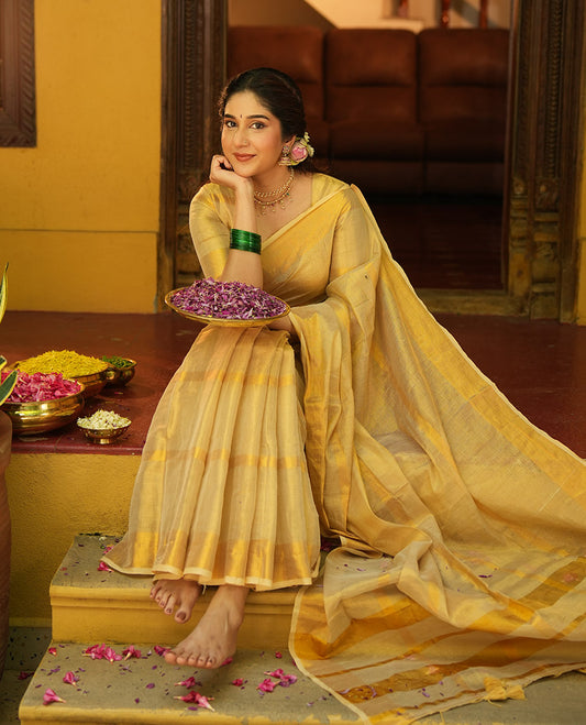Gleaming Gold Khadi Tissue Saree, Elevated with Zari Stripes All Over Its Body, Highlighted by Zari Bavanji Border, Zari Striped Pallu, and Paired with a Matching Blouse