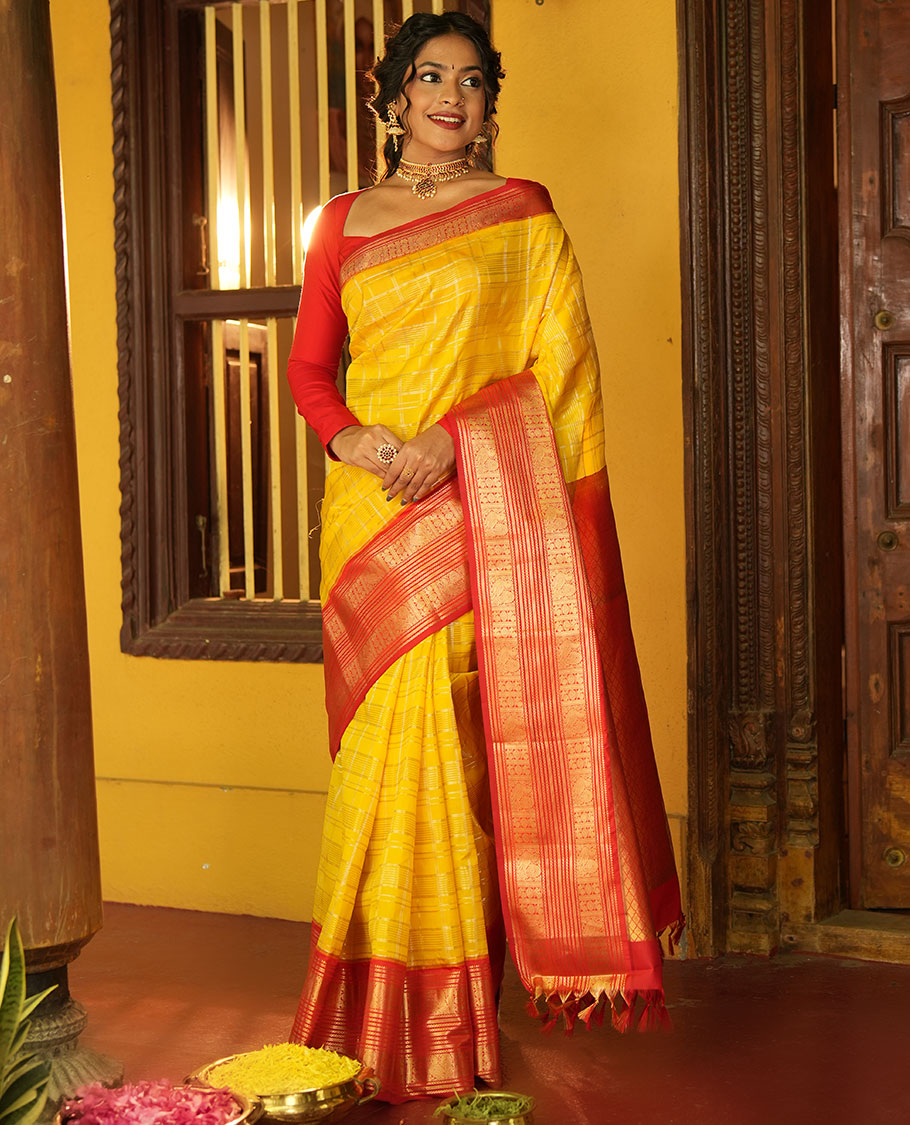 Lemon Yellow and Red Vasundhara Lite Silk Saree, Richly Detailed with Zari Checked Design On Its Body, Complemented by Contrast Varisai Pettu Border of Mayil Chakram Designs, Grand Jaal Pallu, and Paired with a Contrast Blouse