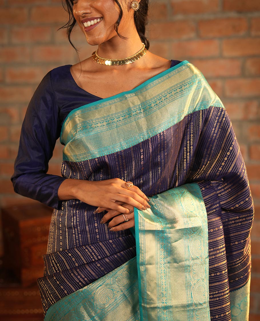 Blue Vasundhara Silk Saree Adorned with Jacquard Design Weave All Over Its Body, Complemented by a Contrast Border of Rekku, Muthu, Laddu Kamalam, Then Kuli Kann, and Dhavana Kodi Designs, Artfully Zari Woven Pallu, and Paired with a Contrast Blouse
