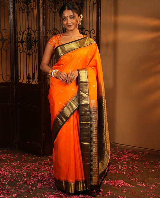 Orange Vasundhara Silk Saree, Artfully Woven with Mayil Buttas All Over Its Body, Complemented by Contrast Border Featuring Thazampoo Rekku, Muthu, Lavangam, and Mayil Kann Designs, a Grand Pallu of Jaal Designs, and Paired with a Contrast Blouse