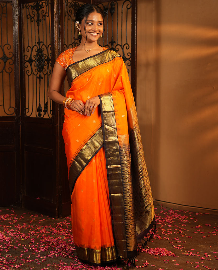 Orange Vasundhara Silk Saree, Artfully Woven with Mayil Buttas All Over Its Body, Complemented by Contrast Border Featuring Thazampoo Rekku, Muthu, Lavangam, and Mayil Kann Designs, a Grand Pallu of Jaal Designs, and Paired with a Contrast Blouse