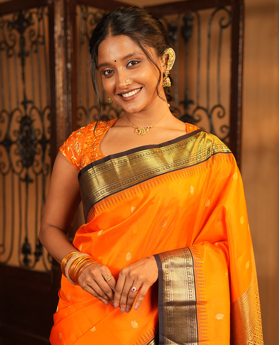 Orange Vasundhara Silk Saree, Artfully Woven with Mayil Buttas All Over Its Body, Complemented by Contrast Border Featuring Thazampoo Rekku, Muthu, Lavangam, and Mayil Kann Designs, a Grand Pallu of Jaal Designs, and Paired with a Contrast Blouse