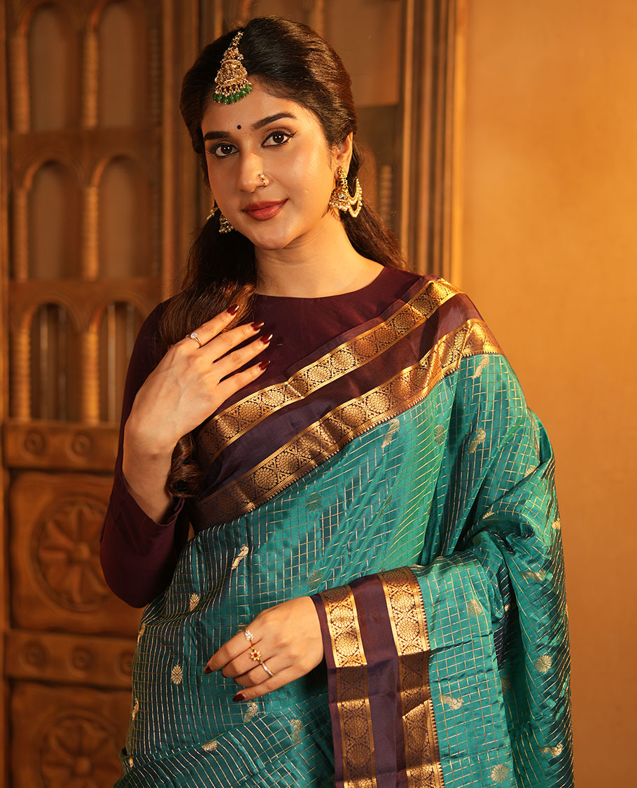 Peacock Color Vasundhara Lite-Silk Mix Saree, Artfully Designed with Mayil-Chakram Buttas and Zari Checks On Its Body, Complemented by Captivating Contrast Border of Rekku, and Chakram Designs, Gracefully Embellished Pallu, Paired with a Contrast Blouse