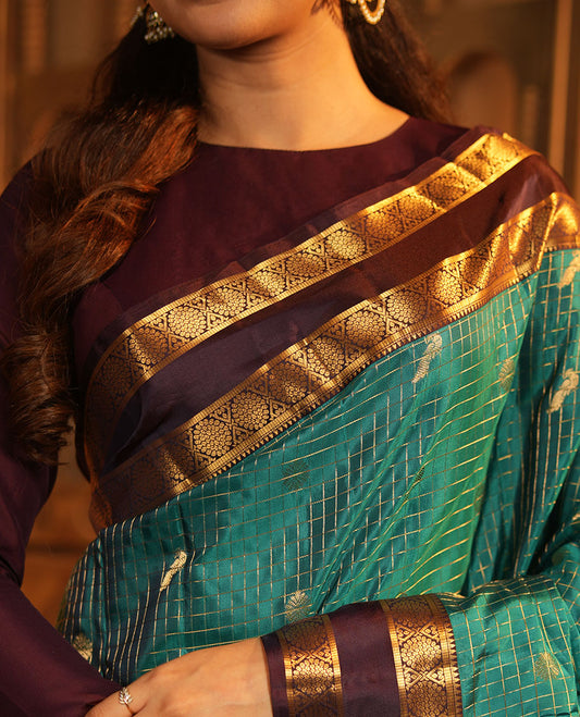 Peacock Color Vasundhara Lite-Silk Mix Saree, Artfully Designed with Mayil-Chakram Buttas and Zari Checks On Its Body, Complemented by Captivating Contrast Border of Rekku, and Chakram Designs, Gracefully Embellished Pallu, Paired with a Contrast Blouse
