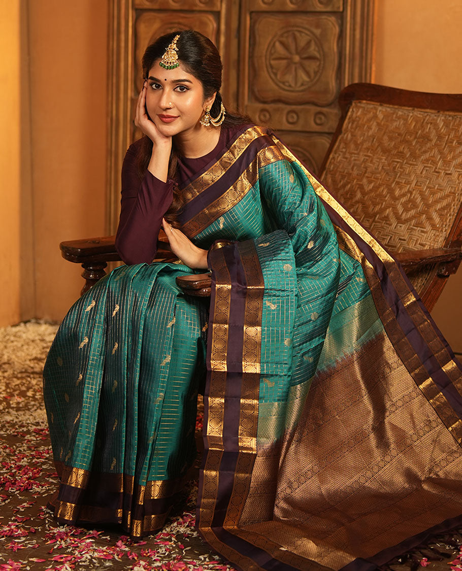 Peacock Color Vasundhara Lite-Silk Mix Saree, Artfully Designed with Mayil-Chakram Buttas and Zari Checks On Its Body, Complemented by Captivating Contrast Border of Rekku, and Chakram Designs, Gracefully Embellished Pallu, Paired with a Contrast Blouse