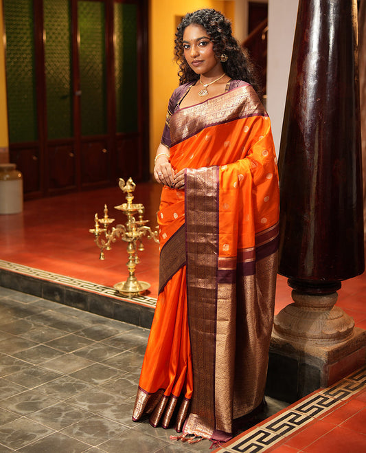Rust Orange Vasundhara Silk Saree, Embellished with Mayil and Yaanai Buttas Across Its Body, Complemented by a Contrast Korvai Border of Rekku, Banaras, Yaanai, and Chakram Designs, Gleaming Jaal Pallu, and Paired with a Contrast Blouse