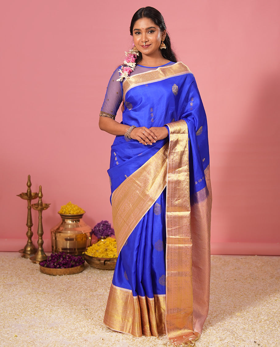 Royal blue floral zari buttas silk saree, contrast border of jada nagam, diamond, kodi visiry, and mayil designs, and zari-rich jaal pallu