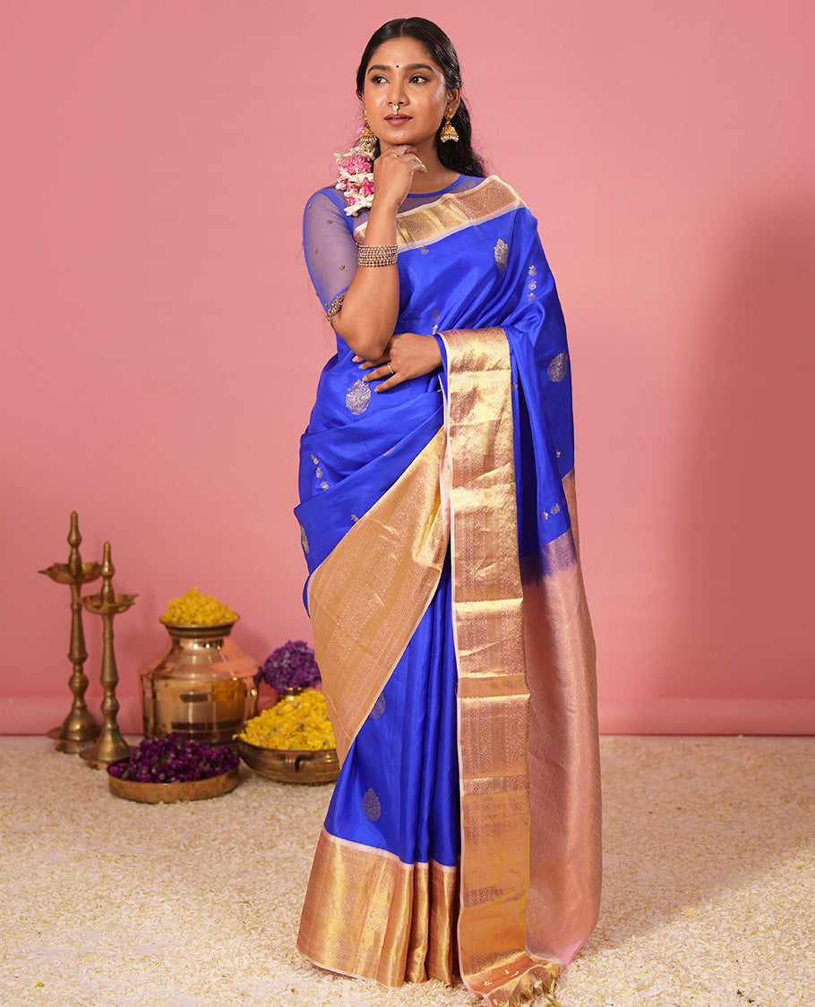 Royal blue floral zari buttas silk saree, contrast border of jada nagam, diamond, kodi visiry, and mayil designs, and zari-rich jaal pallu