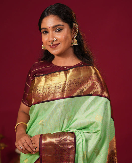 Green zari striped and mayil buttas silk saree, contrast zari border of diamond, muthu, and mayil designs, and jaal pallu