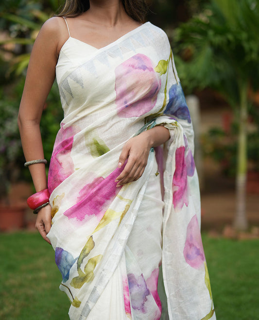 Cream-Base Linen Saree, Highlighted by Floral-Themed Paint Splashes, Hand-Brush Painted All Over Its Body, Sparsely Woven Temple Border, and Paired with a Matching Blouse