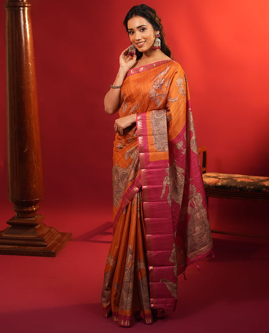 Orange Semi-Tussar Silk Saree, Artfully Detailed with Kalamkari-Style Human Motifs Printed on Its Body, Complemented by a Contrast Temple Zari Border, Creatively Kalamkari Printed Pallu, and Paired with a Contrast Blouse