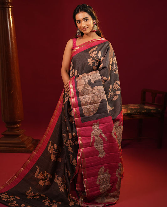 Black Semi-Tussar Silk Saree, Gracefully Detailed with Kalamkari-Style Human Motifs Printed on Its Body, Complemented by a Contrast Temple Zari Border, Creatively Kalamkari Printed Pallu, and Paired with a Contrast Blouse