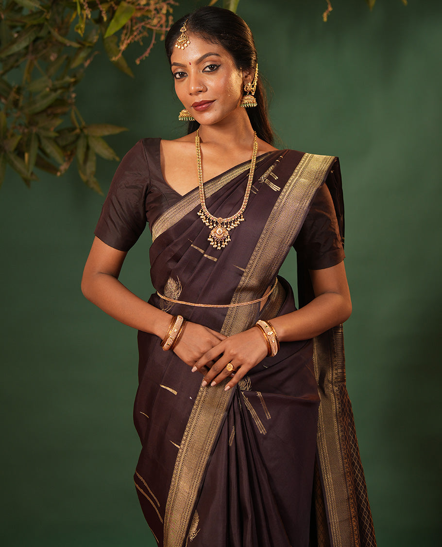Coffee Brown Vasundhara Silk Saree Decked Up with Thazampoo Rekku Buttas and Vel Buttas, Highlighted with a Zari Border of Manga, Muthu, Kathir, Neli, and Vanki Designs, Subtly Sparkled Pallu of Jaal Design, and Paired with a Matching Blouse