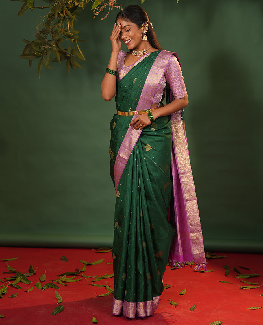 Green Vasundhara Silk Saree Embellished with Yaanai and Mayil Buttas, Complemented by a Contrast Border of Muthu, Kathir, Mayil, and Yaanai Designs, Pallu Embellished with Diagonal Stripes, and Paired with a Contrast Blouse