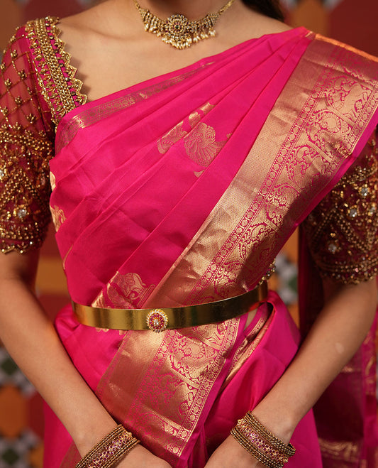 Pink Vasundhara Silk Saree, Spotlighted with Singam and Yaanai Zari Buttas, Highlighted by a Zari Border of Mayil Kann, Rudraksham, Muthu, Mayil, and Yaali Designs, Grandly Zari Decked Up Pallu, and  Paired with a Matching Blouse