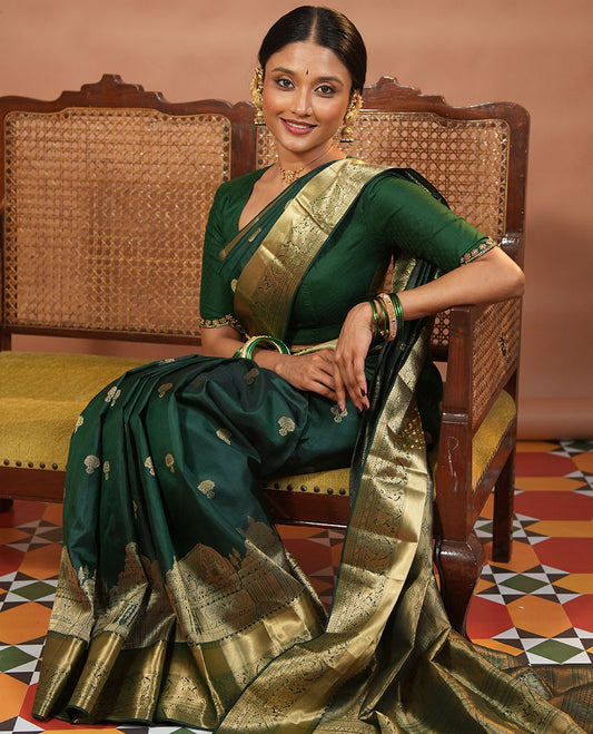 Green Vasundhara Silk Saree Traditionally Decked Up with Zari Buttas and Mamallapuram Temple Motifs, Highlighted by a Zari Border of Salangi, Muthu, Banaras, Mayil, and Lavangam Designs, Gracefully Embellished Pallu, and a Matching Blouse