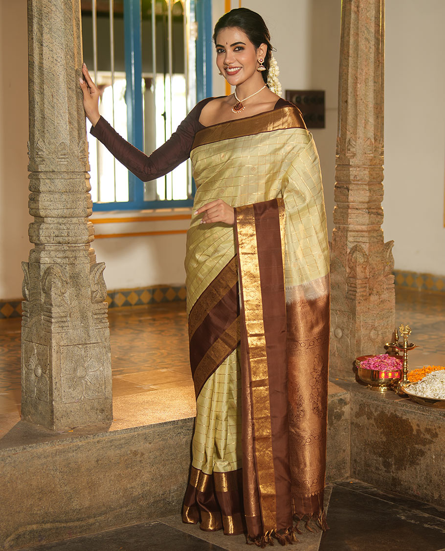 Pale Green Vasundhara Silk Saree, Enriched with Zari Buttas Enclosed Checks All Over Its Body, Complemented by a Contrast Rettai Pettu Border of Muthu, Banaras, and Iruthalai Pakshi Designs, a Grand Pallu, and Paired with a Contrast Blouse