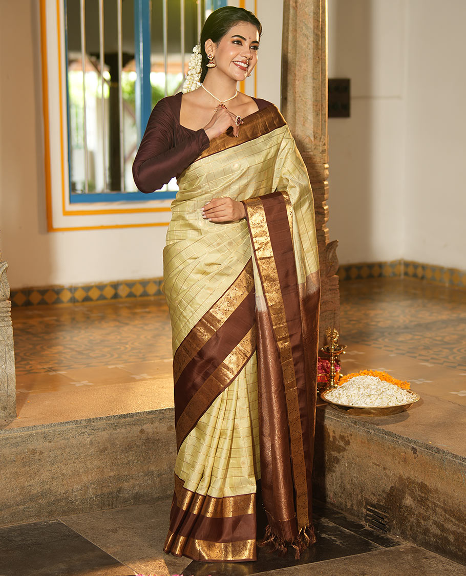Pale Green Vasundhara Silk Saree, Enriched with Zari Buttas Enclosed Checks All Over Its Body, Complemented by a Contrast Rettai Pettu Border of Muthu, Banaras, and Iruthalai Pakshi Designs, a Grand Pallu, and Paired with a Contrast Blouse