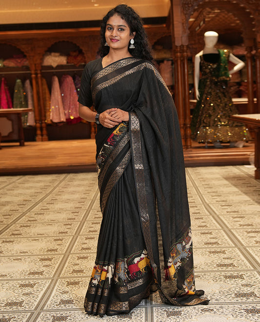 Black Dola Silk Saree Features Vertical Stripes and Pichwai Cow Motifs, Adorned with a Pallu Steeped in Pichwai Cow Motifs, and Paired with a Matching Blouse of Pichwai Lotus Motifs