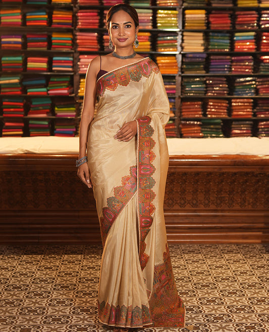 Cream Plain Dola Silk Saree, Complemented by Captivating Contrast Border of Meenakari-style Mughal Human Figurines, Pallu Artfully Pictures Mughal Human Figurines, and Paired with a Matching Blouse