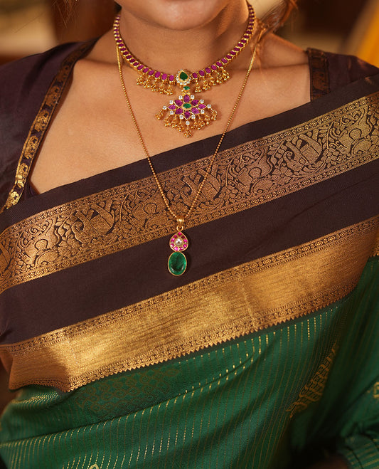 Green Budget Silk Saree, Delicately Woven with Zari Stripes and Kolam Buttas All Over Its Body, Complemented by a Contrast Traditional Zari Design Rettai Pettu Border, Grand Scallop Design Pallu, and Paired with a Contrast Blouse