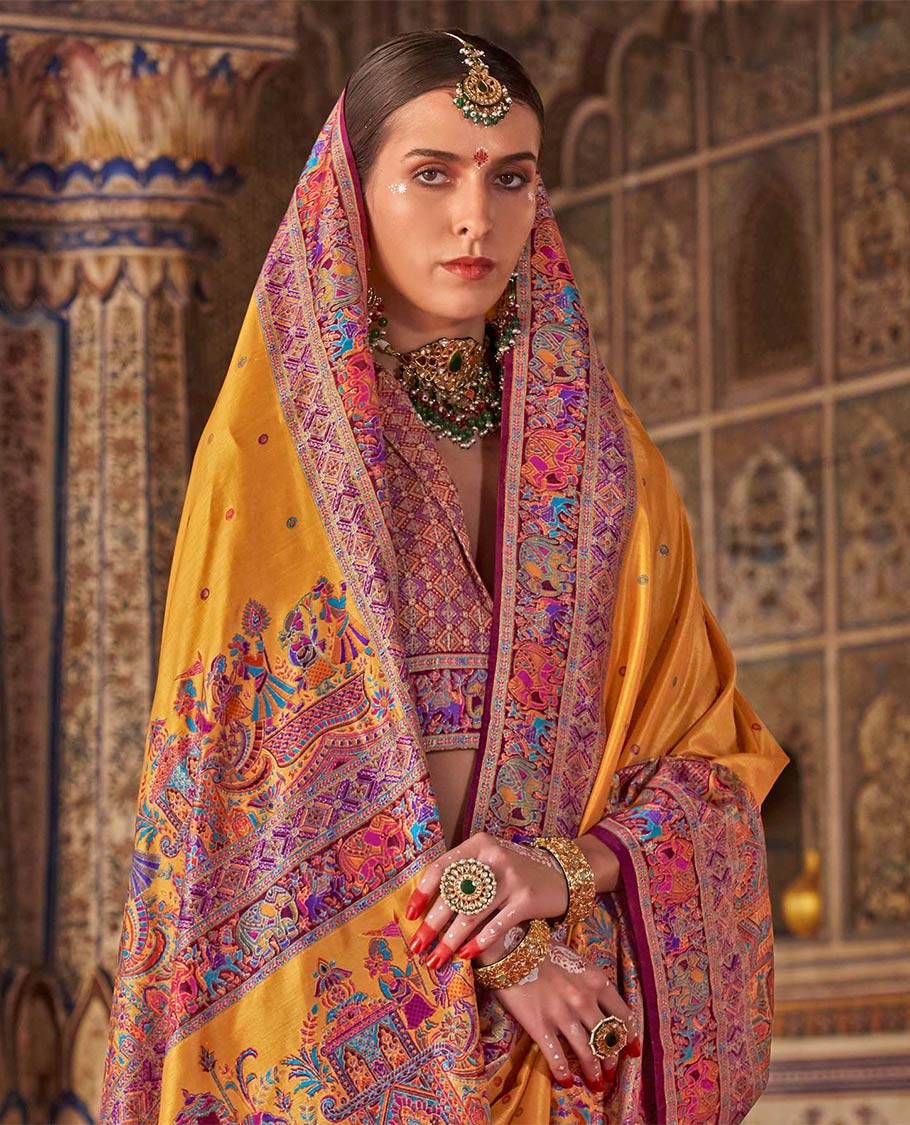 Yellow meena buttas designer catalog saree, contrast meenakari border of human and elephant motifs, and wedding theme meenakari pallu