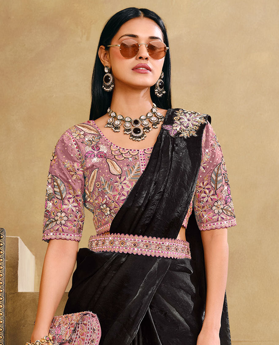 Black Plain Party Wear Designer Saree, Complemented with a Contrast Round Neck Heavy Embroidered Elbow Sleeve Readymade Blouse, Detachable Embroidered Belt, and a Free Embroidered Flap Sling Bag