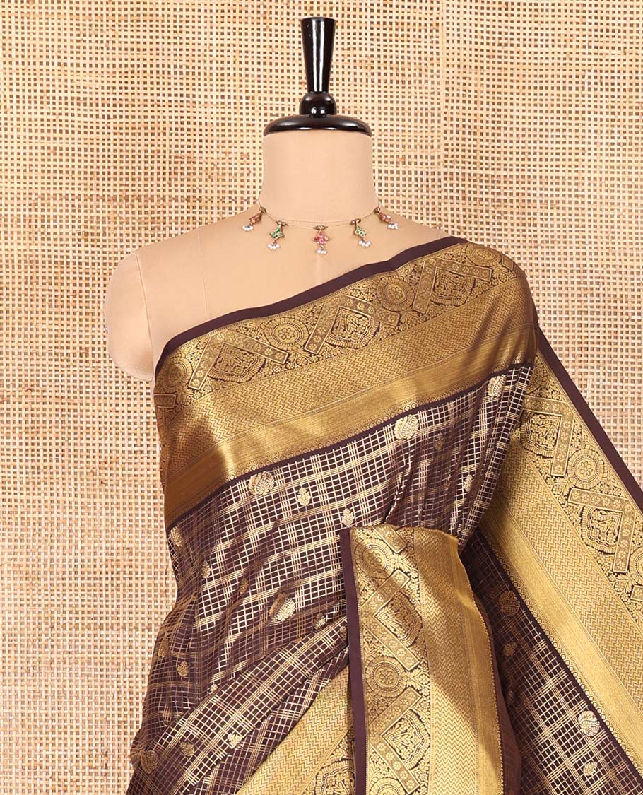 Brown Kanchipuram budget silk saree enriched with zari butta enclosed checks all over its body, complemented by zari traditional design border, Mughal-style intricate pallu, and paired with a Matching blouse