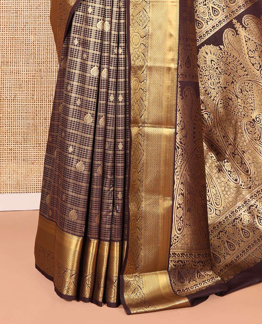 Brown Kanchipuram budget silk saree enriched with zari butta enclosed checks all over its body, complemented by zari traditional design border, Mughal-style intricate pallu, and paired with a Matching blouse