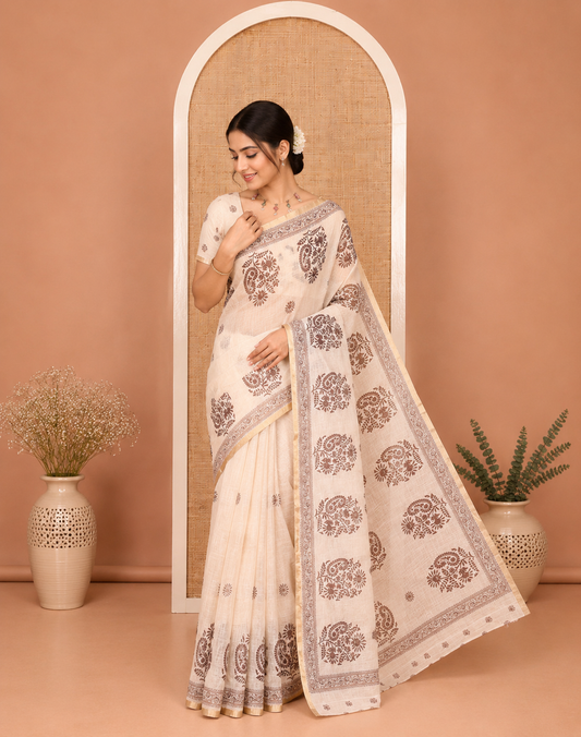 Chikku Linen Cotton Saree, Delicately Designed with Floral-Paisley Motifs Print All Over Its Body, Highlighted by Gold Zari Printed Border, Floral-Paisley Printed Pallu and Paired with a Matching Blouse