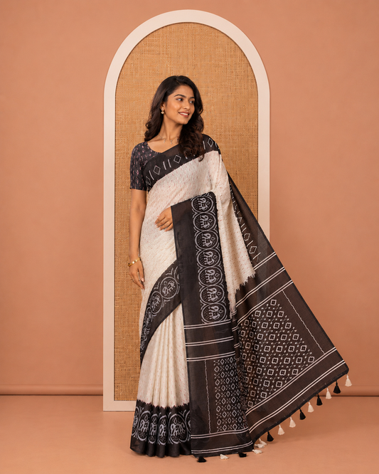 Cream and Black Linen Cotton Saree, Subtly Steeped with Raindrop Style Buttas All Over Its Body, Complemented by Contrast Ikkat Style Border of Elephant Motifs, Ikkat Style Pallu, and Paired with a Contrast Blouse