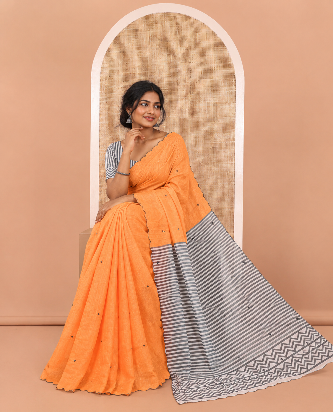Orange Linen Cotton Saree, Subtly Sparkled with Mirror Work All Over Its Body, Subtly Scallop Border, Complemented by Contrast Pallu of Stripes and Mirror Work, and Paired with a Contrast Geometric Printed Blouse