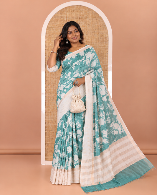 Blue silhouette-style floral discharge printed Assam silk saree, contrast traditional zari border of rudraksham motifs, zari striped pallu, and a floral printed blouse