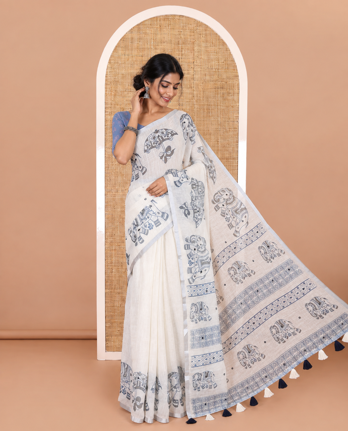Cream mirror work linen cotton saree, zari border of umbrella and elephant motifs print, pallu of print and mirrorwork, and a contrast printed blouse