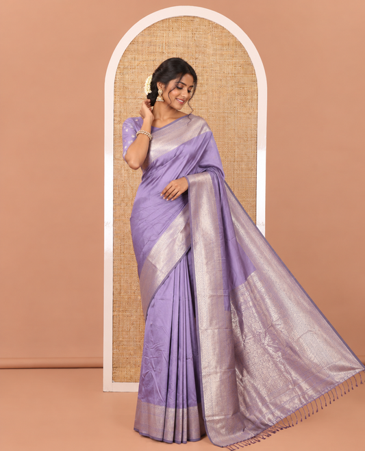 Lavender Plain Semi-Soft Silk Saree, Decked Up with Traditional Zari Designs Woven Border, Grandly Woven Pallu Steeped with Chakram Designs, and Paired with a Matching Blouse