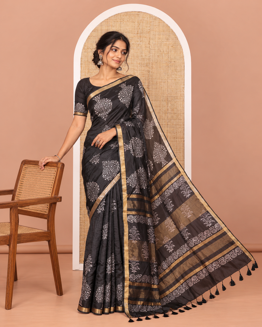 Black tree motifs discharge printed banana pith saree, zari piping border, floral printed pallu, and a tree discharge printed blouse