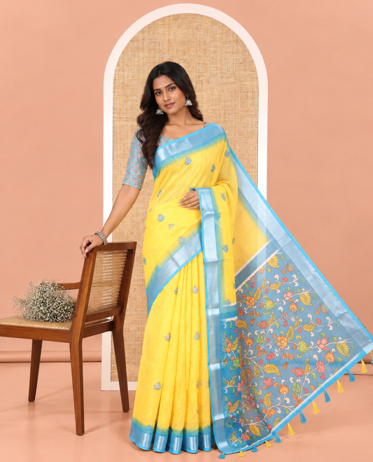 Yellow Linen Cotton Saree, Prettified with Floral Motifs Printed On Its Body, Complemented by Captivating Contrast Bavanji Border, Colorful Floral Vine Printed Pallu, and Paired with a Contrast Blouse