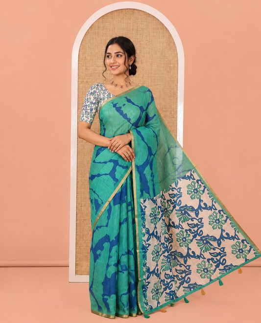Green Linen Cotton Saree, Adorned with Shibori Printed on Its Body, Subtle Piping Border, Pallu of Floral Vine Print, and Paired with a Contrast Floral Vine Printed Blouse