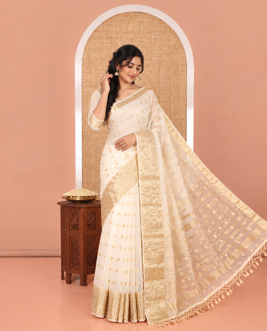 Cream Semi-Organza Saree, Mesmerized with Zari Buttas All Over Its Body, Highlighted by a Zari Jaal-Patterned Border, Gleaming Zari Design Pallu, and Paired with a Matching Blouse