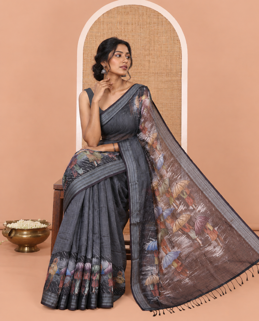 Steel Grey Rain-Themed Printed Linen Cotton Saree, Adorned with People with Umbrellas, a Zari Border, and Matching Blouse
