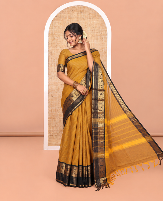 Gold Chettinad Cotton Saree Subtly Sparkled with Stripes All Over Its Body, Complemented by Contrast Traditional Zari Border of Peacock Designs, Subtly Striped Pallu, and Paired with a Matching Blouse