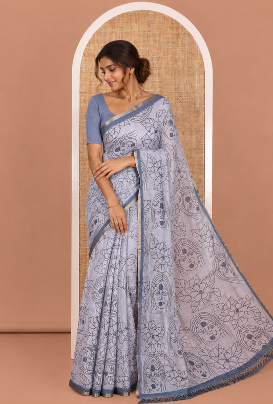 Light Grey Linen Saree Creatively Printed with Girl Face and Floral Motifs All Over Its Body, Subtly Sparkled with Piping Zari Border, Pallu Mirrors the Same Body Print, and Paired with a Contrast Blouse