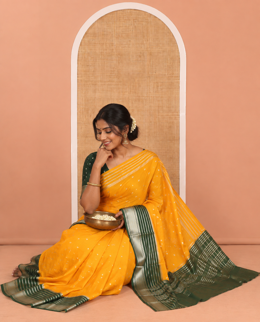 Yellow Art Crepe Saree Features Zari Buttas, Complemented by Contrast Traditional Zari Border, Zari Striped Pallu, and a Contrast Blouse