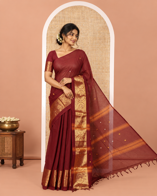 Coffee Brown Chettinad Cotton Saree, Subtly Sparkled with Buttas All Over Its Body, Highlighted Contrast by Zari Traditional Border of Round Chakram Designs, Pallu of Stripes and Buttas, and Paired with a Matching Blouse