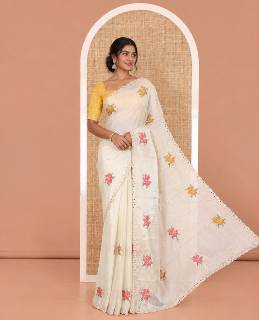 Cream floral motifs embroidered rangoli chiffon saree with mirror work border, embroidered pallu, and a contrast intricate scallop design embroidered blouse