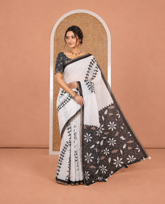 White Linen Cotton Saree Features Warli Print, a Contrast Piping Border, a Floral-Printed Pallu, and a Contrast Blouse