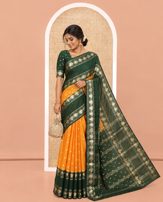 Orange Art Mysore Silk Saree, Decked Up with Zari Buttas All Over Its Body, Complemented by a Contrast Rettai Pettu Border of Two-Headed Eagle Designs, Pallu Steeped with Buttas and Stripes, and Paired with a Contrast Blouse