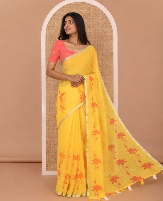 Yellow Pichwai lotus printed linen cotton saree, piping zari border, colorful tasselled lotus printed pallu, and a contrast lotus printed blouse