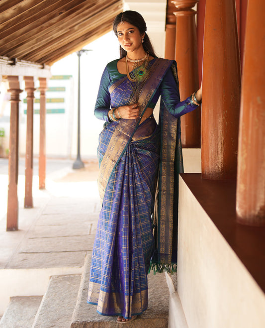 Blue zari buttas enclosed in a checked silk saree, zari border of kuthirai and chakram designs, and intricate zari woven pallu
